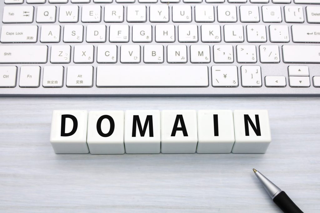 画像：キーボードと「DOMAIN」の文字、ペン